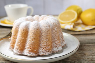 Tahta masaya pudra şekerli lezzetli limonlu pasta, yakın plan.