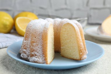 Açık dokulu masaya pudra şekerli lezzetli limonlu pasta, yakın plan.