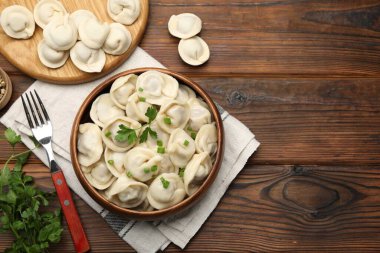 Delicious dumplings served on wooden table, flat lay. Space for text