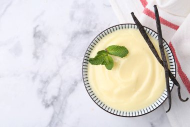 Lezzetli vanilyalı puding, nane ve kapsüller beyaz mermer masa, üst manzara. Metin için boşluk
