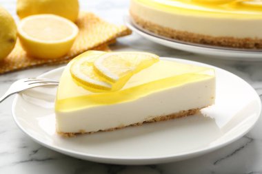 Lezzetli limonlu cheesecake ve çatal beyaz mermer masada, yakın plan.