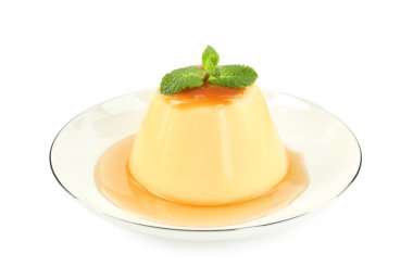 Karamel soslu lezzetli puding ve beyaz üzerine izole edilmiş nane.