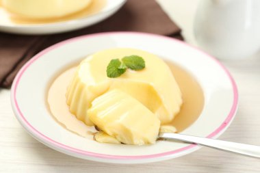 Karamel soslu lezzetli puding ve beyaz masada servis edilen nane şekeri.