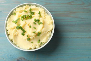 Açık mavi ahşap masada yeşil soğanlı leziz patates püresi. Metin için boşluk