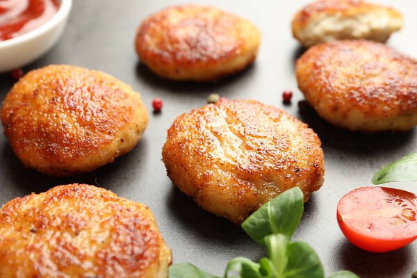 Вкусные пирожки, шпинат и помидор на сером текстурированном столе, крупный план