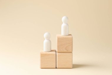 Rekabet konsepti. Bej arka plana karşı tahta küplerdeki insan figürleri