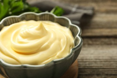 Tahta masadaki kasede mayonez sosu, yakın plan.