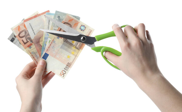 Woman cutting euro banknotes on white background, closeup