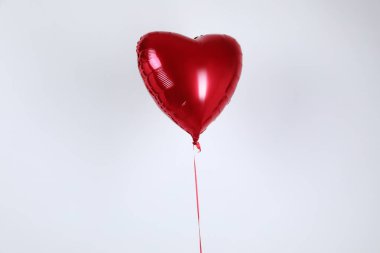 Işık arka planında kalp şeklinde bir kırmızı balon. Sevgililer Günü