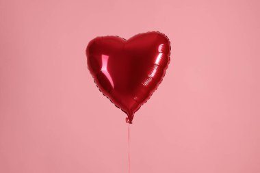 Pembe arka planda kırmızı bir kalp şeklinde balon. Sevgililer Günün kutlu olsun.