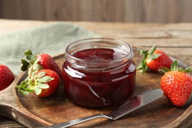 Lezzetli çilek sosu ve ahşap masada taze böğürtlen, yakın plan.