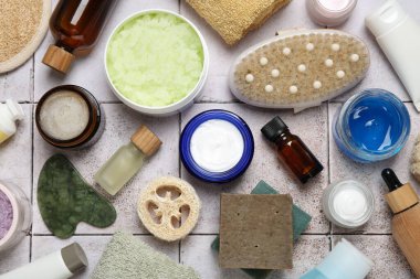 Hafif fayanslı masa üzerinde farklı vücut bakım ürünleri, düz uzanma