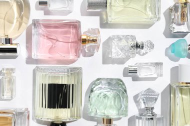 Farklı aromatik parfümler beyaz arka planda şişelerde, düz yerde