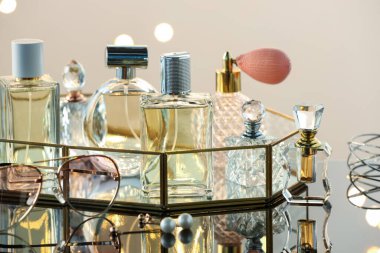 Cam yüzeyde farklı lüks parfümler, yakın plan. Bokeh etkisi