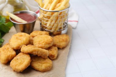 Lezzetli tavuk nugget, patates kızartması ve ketçap beyaz fayanslı masada, yakın plan. Metin için boşluk