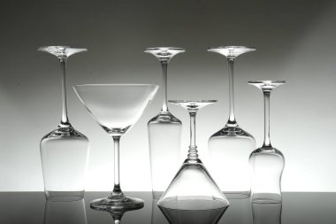 Gri arkaplana karşı ayna yüzeyinde birçok boş bardak