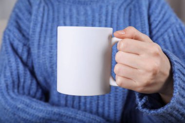 Elinde boş beyaz seramik bardak tutan kadın, yakın plan. Tasarım için model