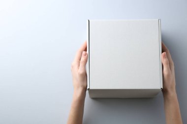Beyaz arka planda boş karton kutusu olan kadın, yakın plan. Tasarım için model