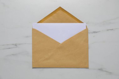 Beyaz mermer zemin üzerinde harf olan Kraft kağıt zarf, üst görünüm. Tasarım için model