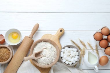 Hamur için merdane ve malzemeler beyaz ahşap masada, düz yerde. Metin için boşluk