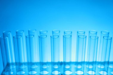 Açık mavi arka planda test tüpleri, yakın plan. Laboratuvar camları.