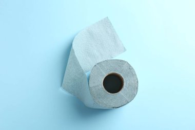 Açık mavi arkaplanda renkli tuvalet kağıdı rulosu, üst görünüm
