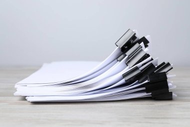 Tahta masadaki kağıtların olduğu ataçlar, yakın plan.