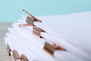 Masanın üzerinde kağıt kağıtları olan ataçlar, yakın plan