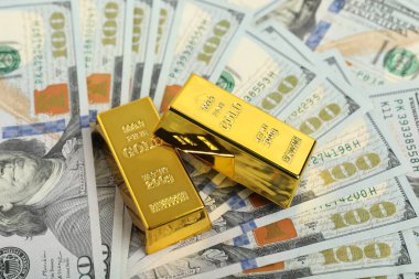 Dolar banknotları üzerinde iki parlak altın külçe