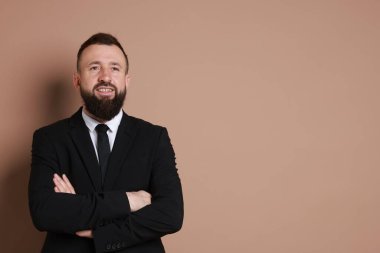 Kahverengi arka planda takım elbiseli yakışıklı sakallı adam. Metin için boşluk
