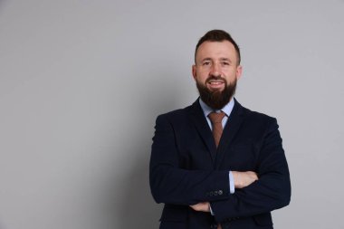 Gri arka planda takım elbiseli yakışıklı sakallı adam. Metin için boşluk