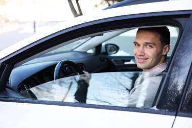 Çağdaş arabanın direksiyonundaki sürücü, dışarıdan görüş.