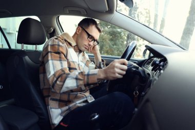 Modern arabasında uyuyan yorgun sürücü.