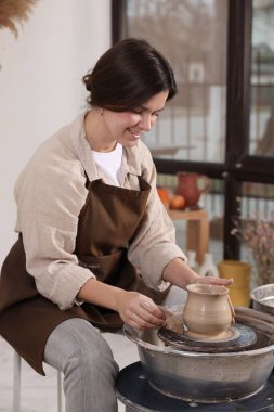 Hobi ve zanaat. Gülümseyen kadın içeride çömlek yapıyor.