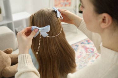 Annem evde kızının saçına sevimli aksesuarlar takıyor.