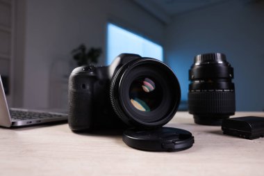 Profesyonel fotoğraf makinesi, lens ve laptop ahşap masa içinde, seçici odak