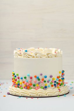 Masanın üzerine renkli şekerlemeler serpiştirilmiş nefis bento keki