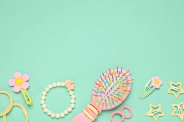 Farklı saç aksesuarları ve turkuaz arka planda fırça, düz yatak. Metin için boşluk