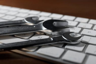 Teknik destek konsepti. Ahşap arkaplanda anahtarlar ve klavye, yakın plan