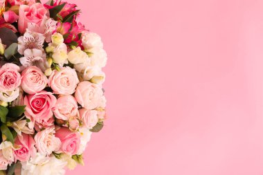 Pembe arka planda bir buket güzel çiçek, üst manzara. Metin için boşluk