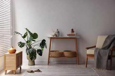 Beyaz duvarın yanında konsol masası olan şık bir oda.