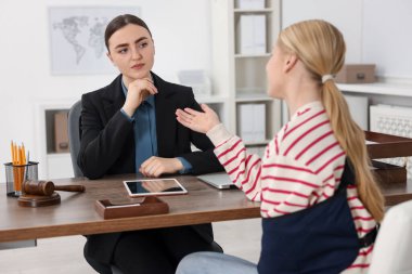 Yaralı kadın, ofiste avukatla görüşüyor, seçici odaklı.