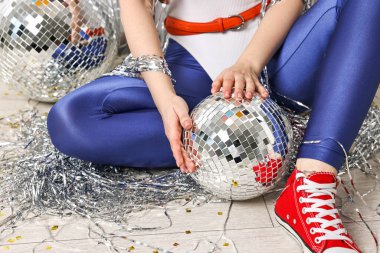 Eski moda elbiseli bir kadın ve yerde disko topları var, yakın plan.