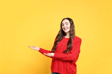 Mutlu kadın sarı arka plandaki arkadaşları ya da konukları karşılıyor.