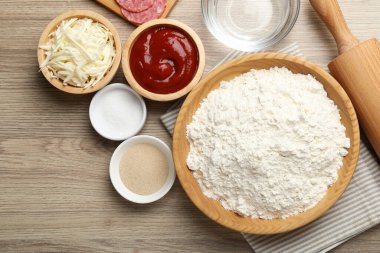 Calzone pizzası yapıyorum. Tahta masadaki farklı malzemeler.