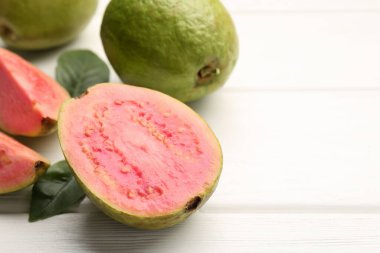 Taze taze ve beyaz ahşap masada guava meyveleri, yakın plan. Metin için boşluk