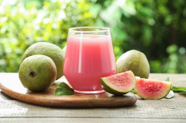 Guava suyunu tazeliyorum ve ahşap masada taze meyveler, yakın plan.