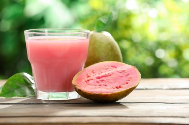 Guava suyunu tazeliyorum ve ahşap masada taze meyveler, yakın plan. Metin için boşluk
