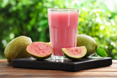 Guava suyunu tazeliyorum ve ahşap masada taze meyveler, yakın plan.
