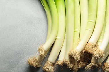 Açık gri masada taze yeşil pırasa, üst manzara. Metin için boşluk